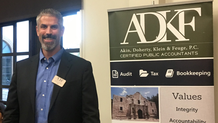 Man standing beside ADKF banner.