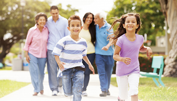 Children running with family in park.