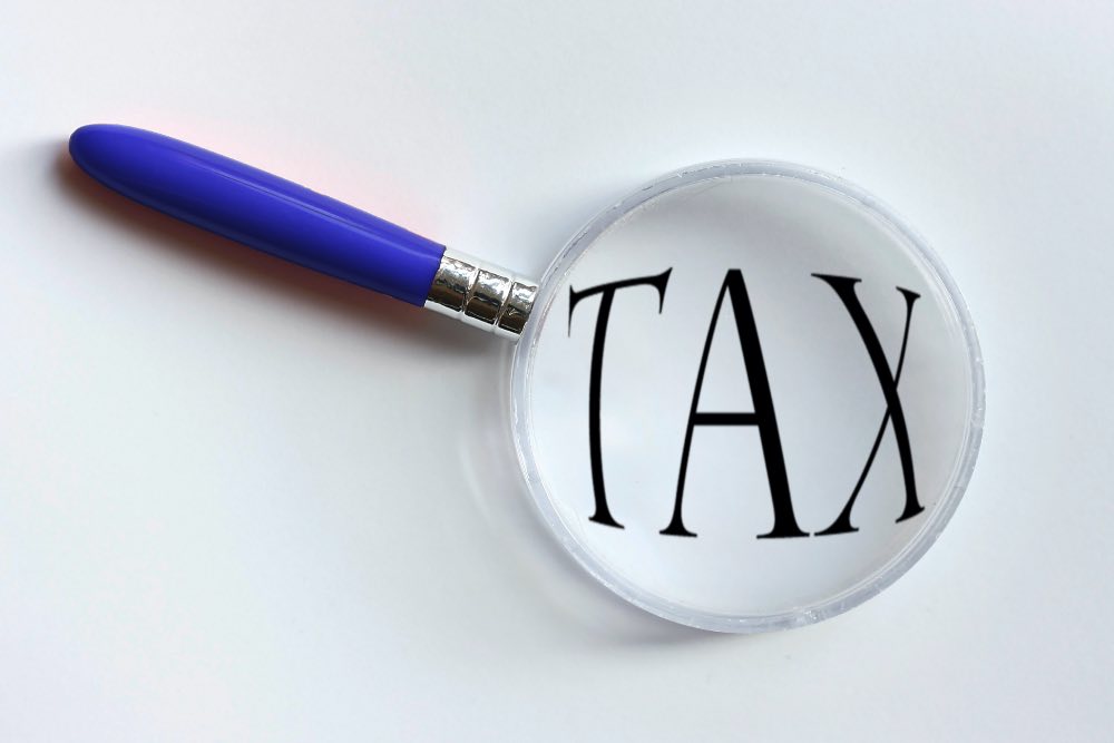 Magnifying glass over the word 'TAX'