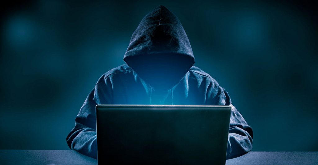 Person in hoodie using laptop