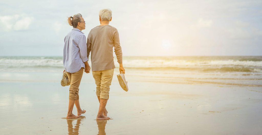 Couple walking on the beach together.