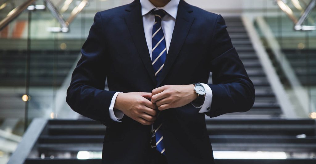 Man adjusting suit in modern setting