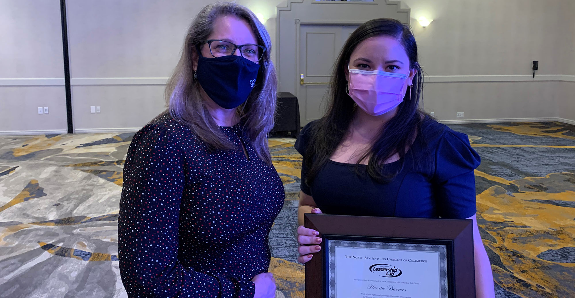 Two women holding a certificate.