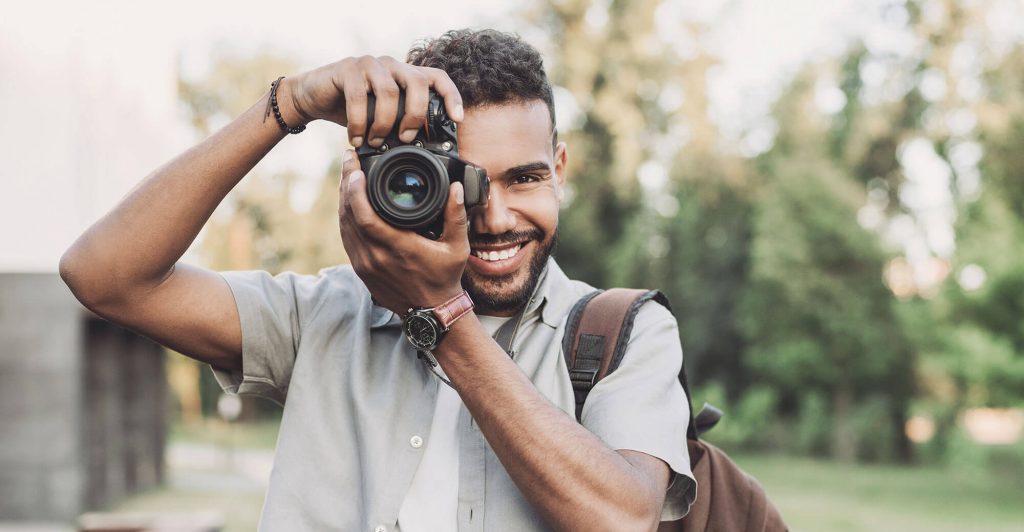 Person taking photo outdoors with camera