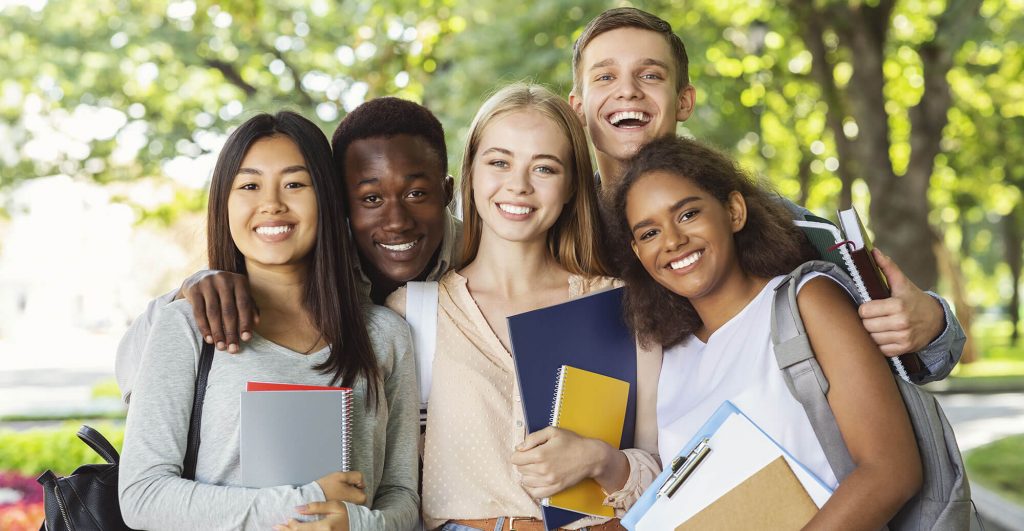 Group of students outdoors, smiling together.