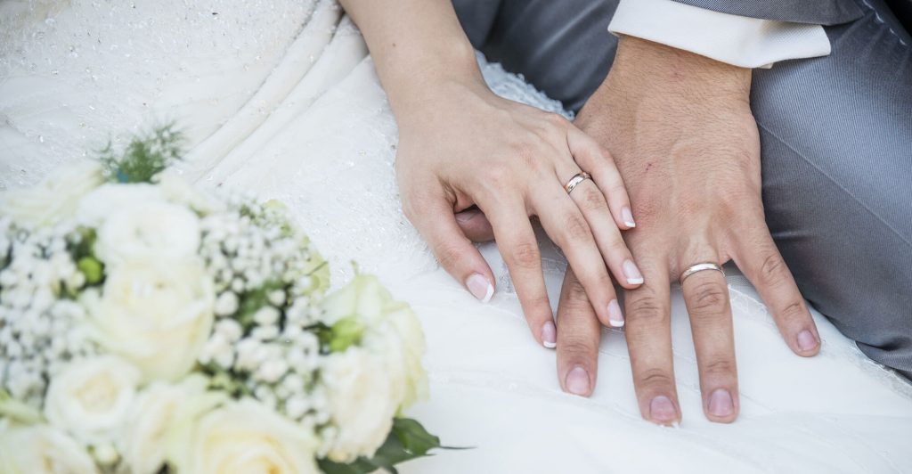Couple's hands with wedding rings.