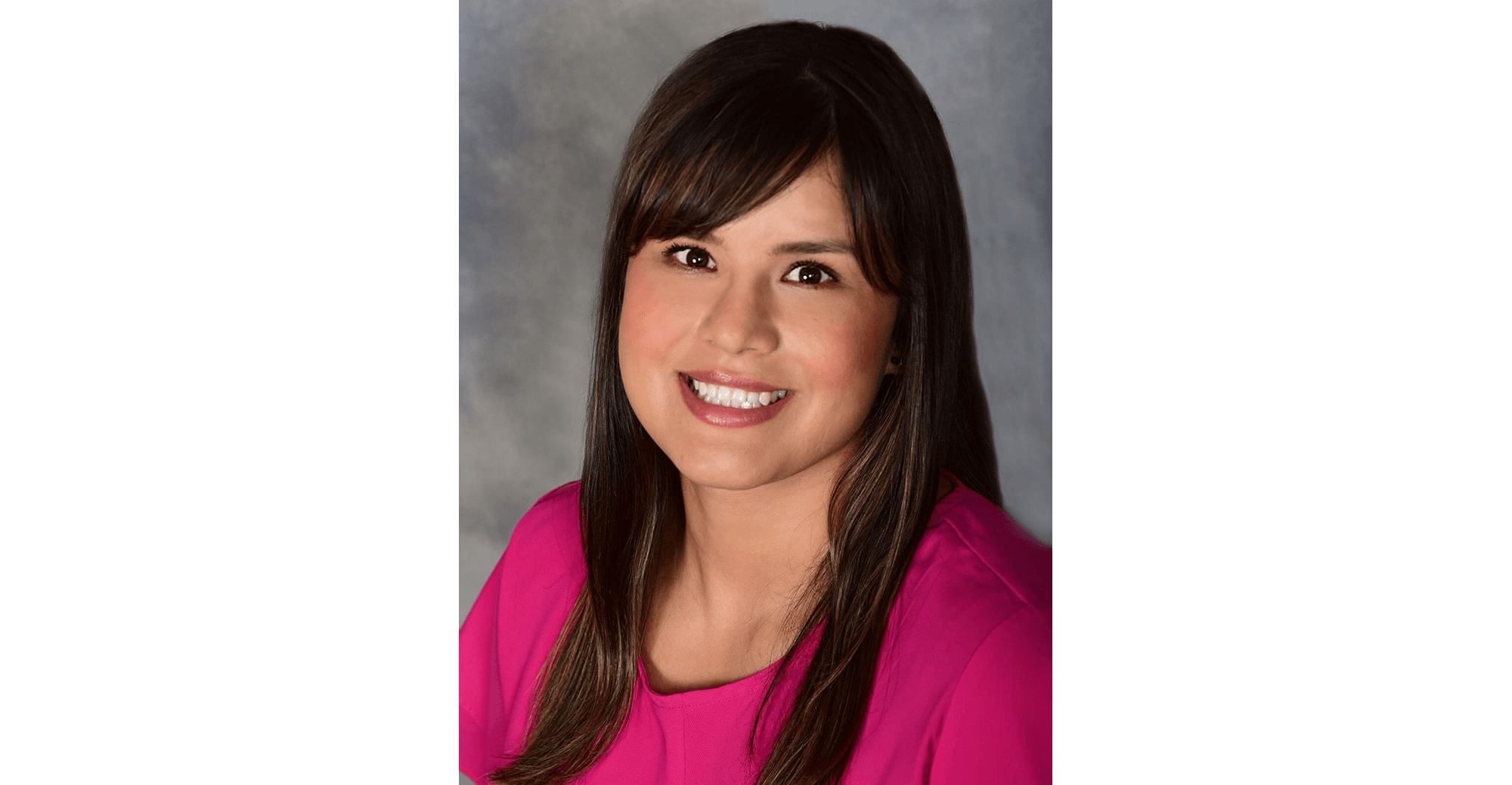 Woman in pink top, neutral background.