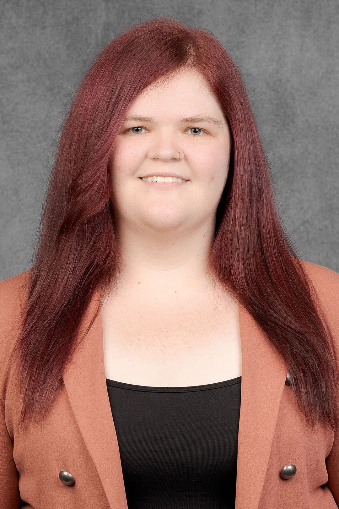 Woman with long red hair, blazer.
