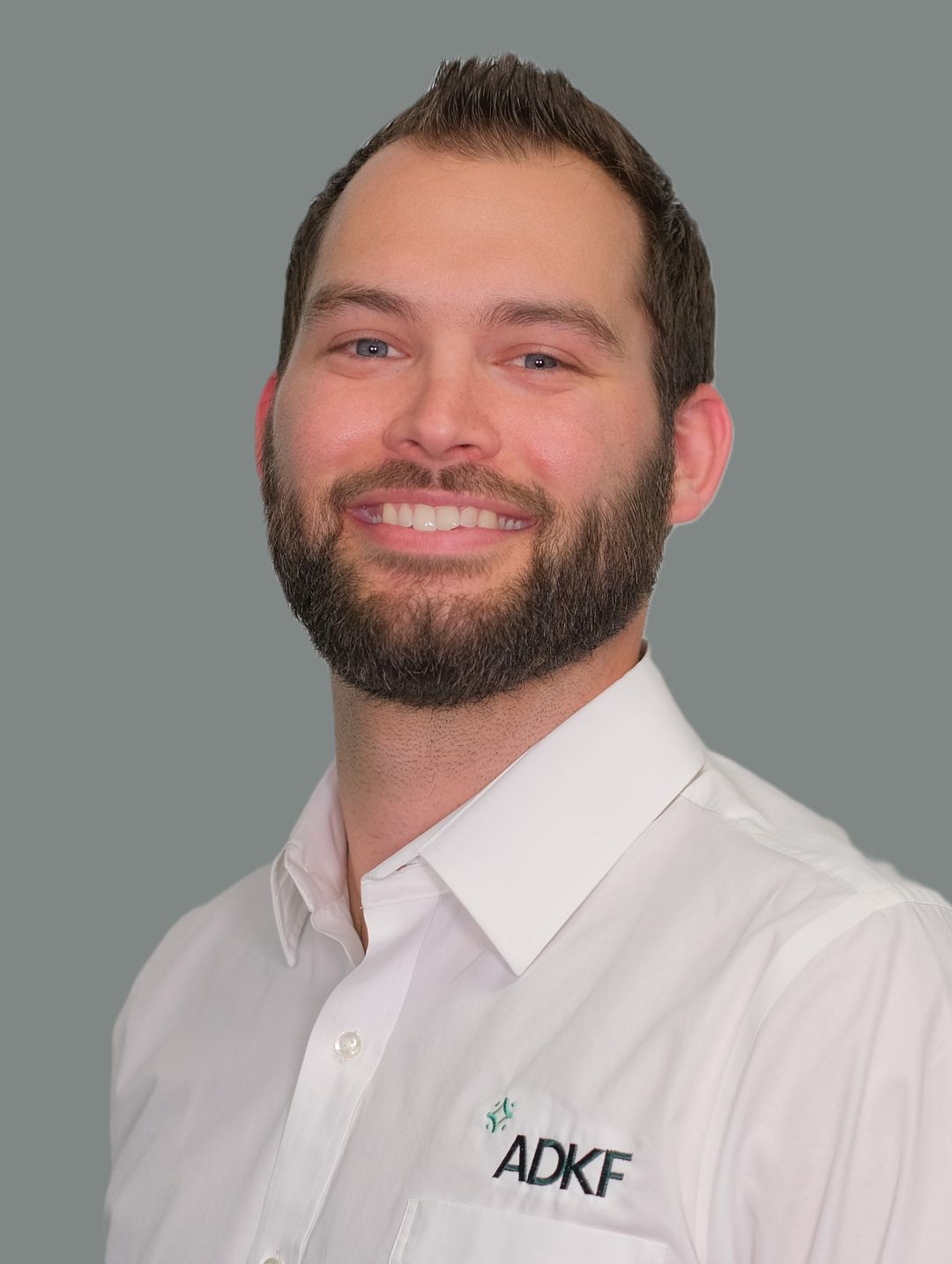 Man in white shirt, gray background.