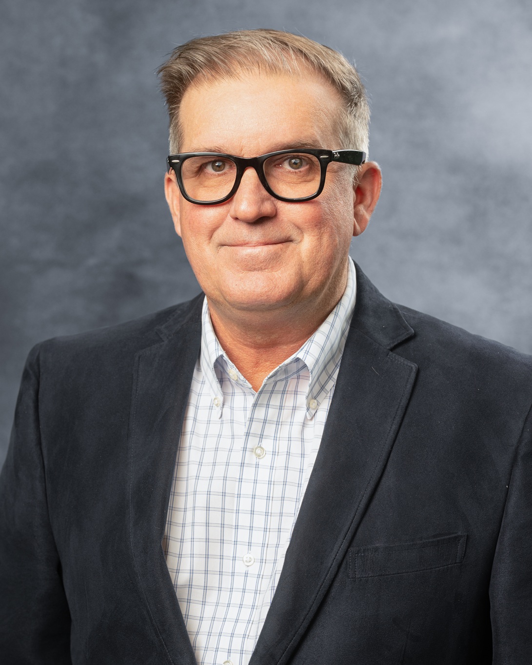 Man in blazer with checkered shirt.