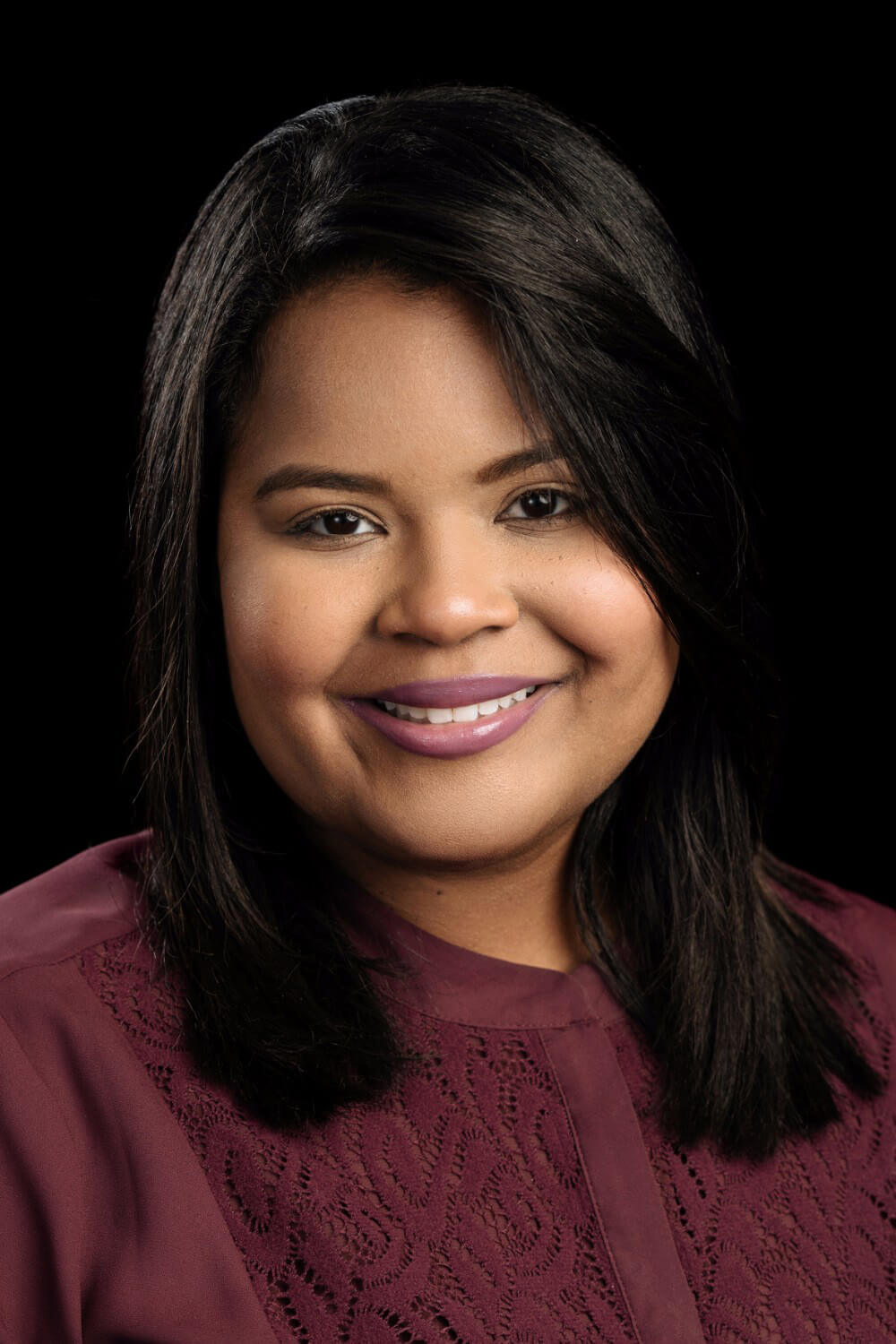 Person with dark hair, wearing maroon top.